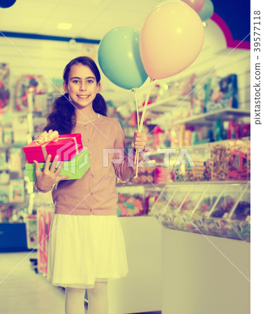Girl with gifts in toys shop Girl with gifts in toys shop 39577118