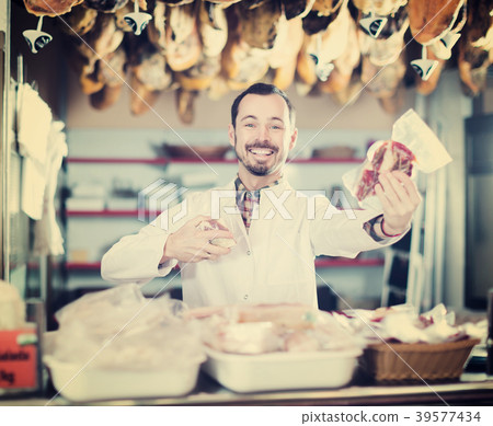 Seller offering displayed sorts of meat Seller offering displayed sorts of meat 39577434