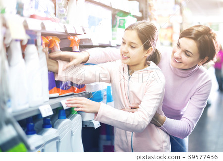 Woman with girl looking for cleaners in supermarket 39577436