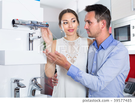 Smiling husband and wife are choosing new mixer tap Smiling husband and wife are choosing new mixer tap 39577485