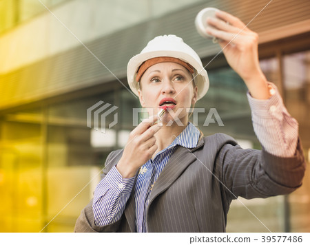 Employee woman using lipstik Employee woman using lipstik 39577486