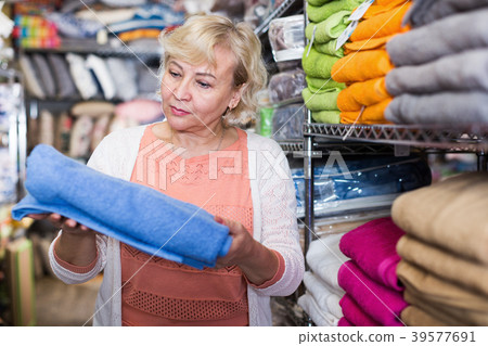Mature female customer looking cotton colour towel Mature female customer looking cotton colour towel 39577691