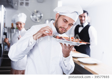Chef checking dishes in kitchen of fish restaurant Chef checking dishes in kitchen of fish restaurant 39577693