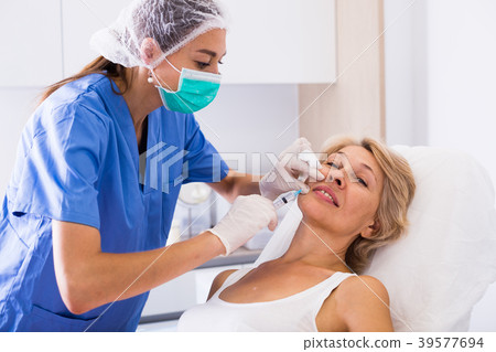 Senior woman getting facial injection Senior woman getting facial injection 39577694