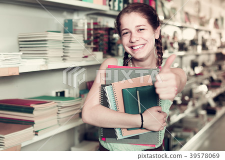 teenager buying different products in stationery shop 39578069