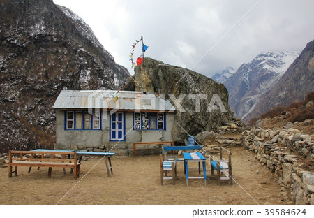 Small restaurant attached to a big boulder. 39584624