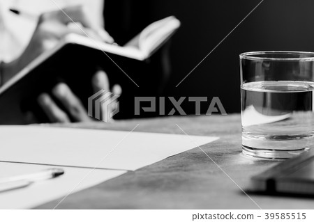 The man is writing in a notebook in a workplace The man is writing in a notebook in a workplace 39585515
