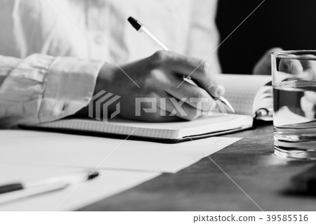 The man is writing on a white paper sheet The man is writing on a white paper sheet 39585516