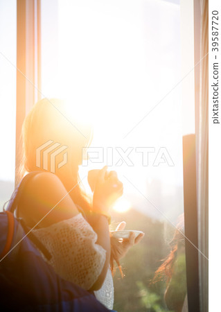 Photo of long-haired pensive woman with cup of tea 39587720