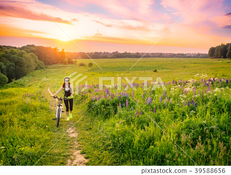 Young sporty woman riding a bicycle at sunset 39588656