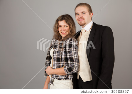 Elegant couple smiling for the camera while Elegant couple smiling for the camera while 39588867