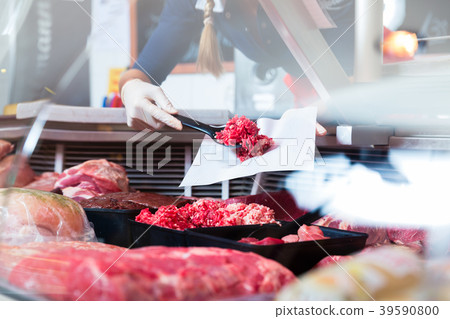 Meat in a butcher shop display being put in by Meat in a butcher shop display being put in by 39590800
