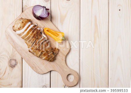 Grilled chicken fillets on wooden board with onion Grilled chicken fillets on wooden board with onion 39599533