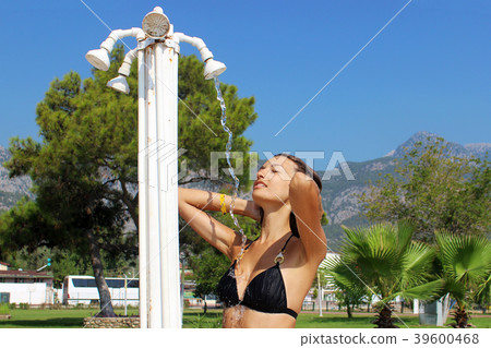 Sensous slim woman taking shower at the beach 39600468