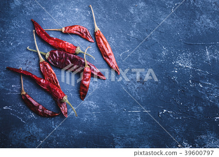 Dried chili peppers on blue concrete background Dried chili peppers on blue concrete background 39600797