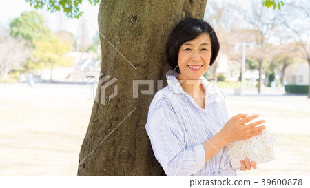 Woman talking under a big tree in Yamashita Park Woman talking under a big tree in Yamashita Park 39600878