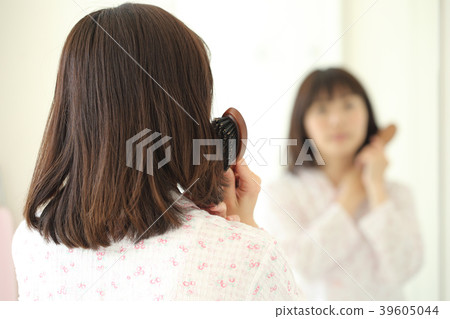 A woman stroking her hair A woman stroking her hair 39605044
