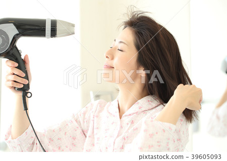 A woman wearing a hair dryer A woman wearing a hair dryer 39605093