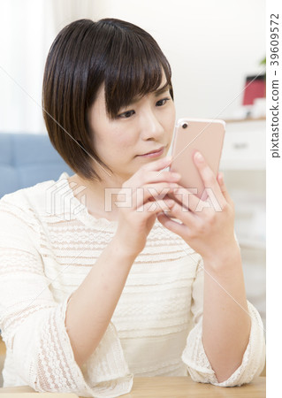 操作智能手機的一個少婦 操作智能手機的一個少婦 39609572