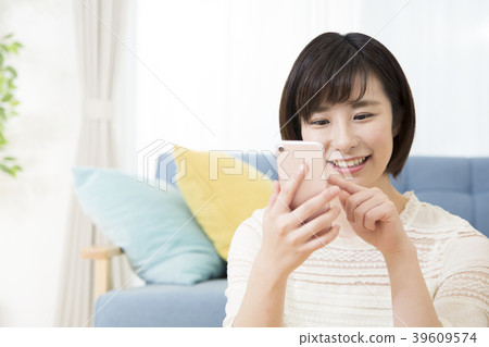 A young woman operating a smartphone 39609574