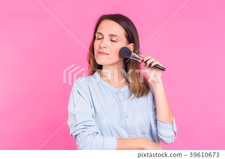 Beautiful young woman applying cosmetic powder on 39610673