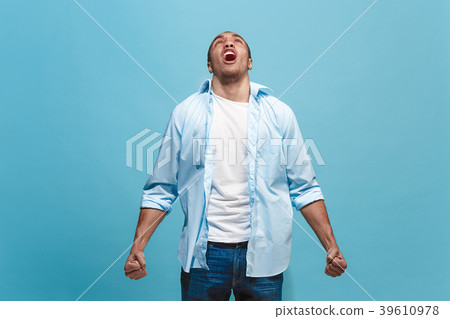The young emotional angry man screaming on blue 39610978