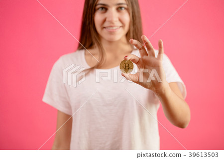 beautiful woman is holding golden coin. Female has beautiful woman is holding golden coin. Female has 39613503