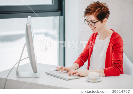 businesswoman typing on keyboard in bright office 39614767