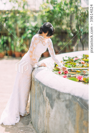 Beautiful bride touching the waterlilia in the Beautiful bride touching the waterlilia in the 39614824