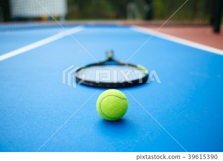 Tennis ball is laying in front of racket on opened 39615390