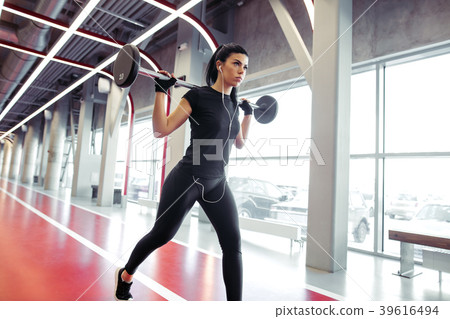 girl doing lunges with barbell in modern gym girl doing lunges with barbell in modern gym 39616494