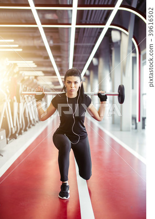 girl doing lunges with barbell in modern gym girl doing lunges with barbell in modern gym 39616502