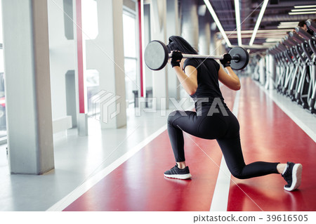 girl doing lunges with barbell in modern gym girl doing lunges with barbell in modern gym 39616505