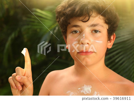 teenager boy with sun screen protection cream close up smiling photo teenager boy with sun screen protection cream close up smiling photo 39616911