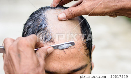 Shaved hair for ordained Buddhist man 39617329