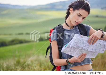 women with paper map waving at car on a concrete road in the cou 39617942