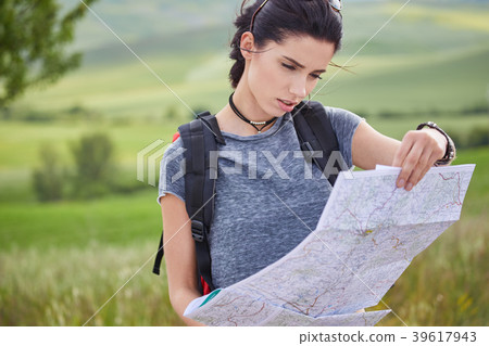 women with paper map waving at car on a concrete road in the cou women with paper map waving at car on a concrete road in the cou 39617943