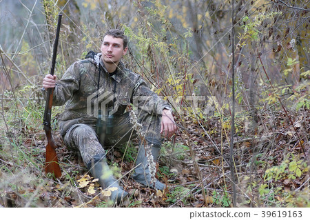 Man in camouflage and with guns in a forest belt Man in camouflage and with guns in a forest belt 39619163