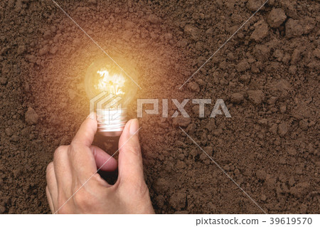 Hand with light bulbs with glowing on ground. 39619570