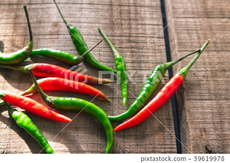 Sunlight ray on red and green chili on the wood  39619978