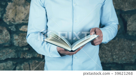 Young man opening and reading a book. Young man opening and reading a book. 39621268