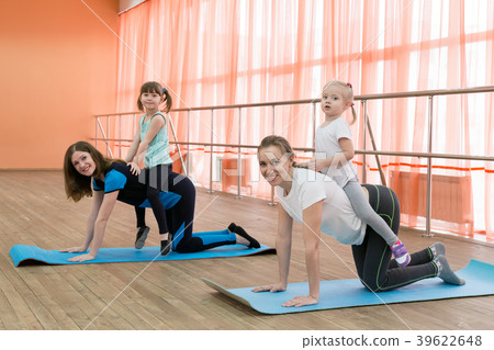 A woman is engaged in sports with a child on her b A woman is engaged in sports with a child on her b 39622648