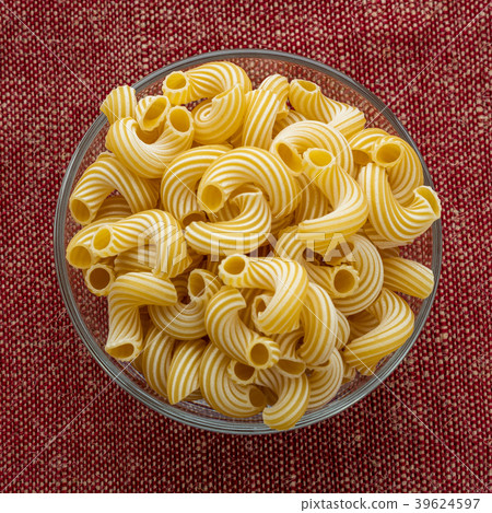 rigati pasta in a glass bowl on a red brown cloth rigati pasta in a glass bowl on a red brown cloth 39624597