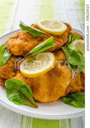 Fried schnitzel with herbs and lemon Fried schnitzel with herbs and lemon 39628425