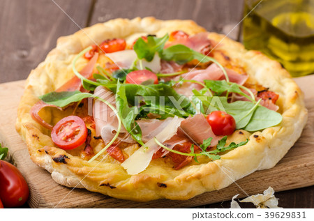 Italian pizza with parmesan cheese, prosciutto and arugula 39629831