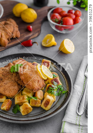 Schnitzel original with lemon and gnocchi fried Schnitzel original with lemon and gnocchi fried 39631279