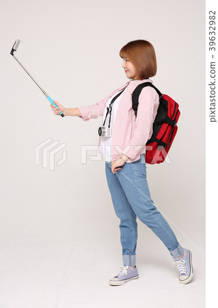Young traveler woman with a backpack concept isolated on White photo. 064 39632982