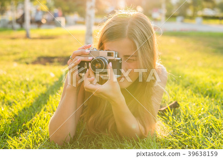Smiling young woman using a retro camera to take Smiling young woman using a retro camera to take 39638159