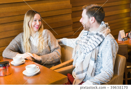 Happy young couple is talking and drinking coffee Happy young couple is talking and drinking coffee 39638170