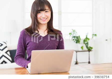 觀看一台便攜式計算機的婦女在屋子裡 觀看一台便攜式計算機的婦女在屋子裡 39638754